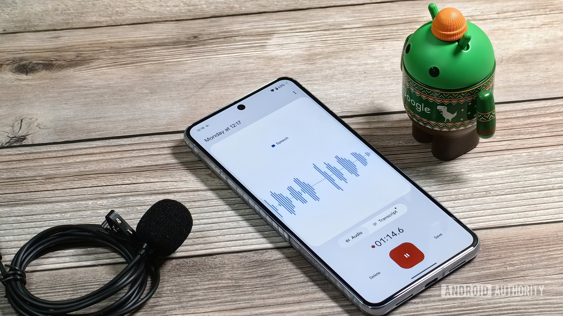 A Bot looking at a Pixel 8 Pro running the Pixel Recorder app next to a wired microphone A Bot looking at a Pixel 8 Pro running the Pixel Recorder app next to a wired microphone